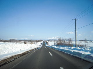 Fototapeta premium 冬の道東の一本道と知床連山の遠望（北海道）