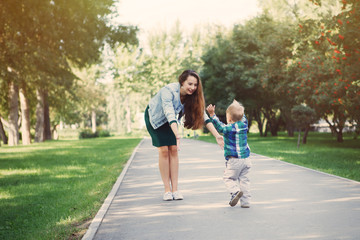 Young mother with little son having fun playing in the Park