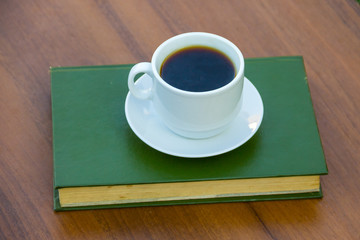 Fototapeta na wymiar Cup of coffee and book on wooden table