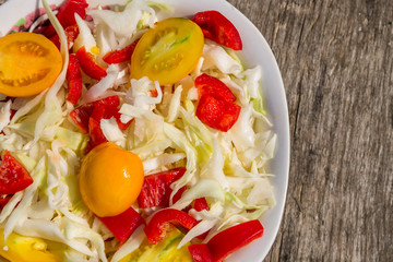 Fresh vegetable salad on rustic wooden table