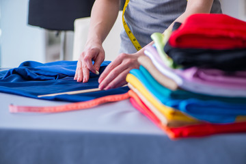 Woman tailor working on a clothing sewing stitching measuring fa