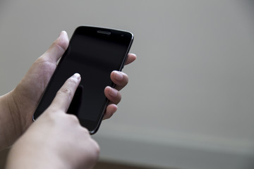 Female hand holding the smartphone Black color