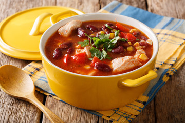 Chili chicken with red beans, corn and tomatoes close-up in a bowl. horizontal