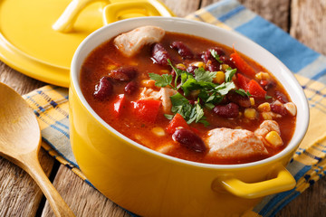 Spicy chicken with chili, red beans, corn and tomatoes close-up in a bowl. horizontal