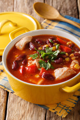 Soup of chicken with chili, beans, corn and tomatoes close-up in a bowl on the table. vertical