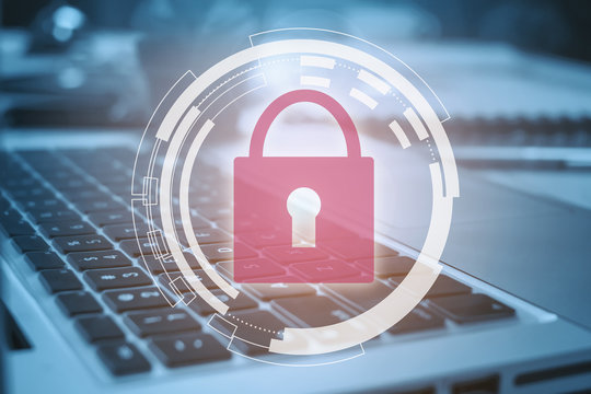 Business, technology, internet and networking concept. Young businessman working on his laptop in the office, select the icon security on the virtual display.