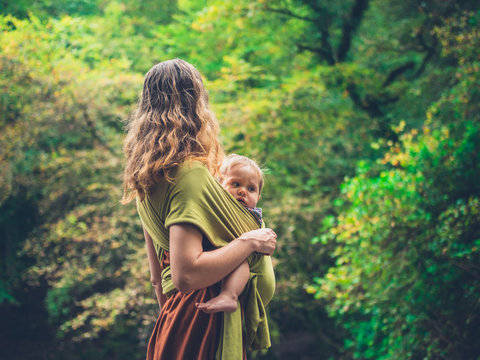 Mother with baby in sling in nature