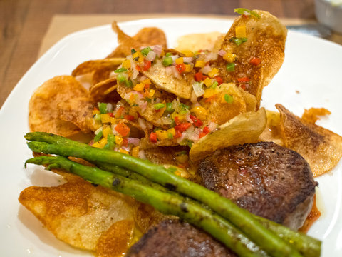 Steak Filet With Chips Salsa Asparagus on White Plate in Chilean Restaurant