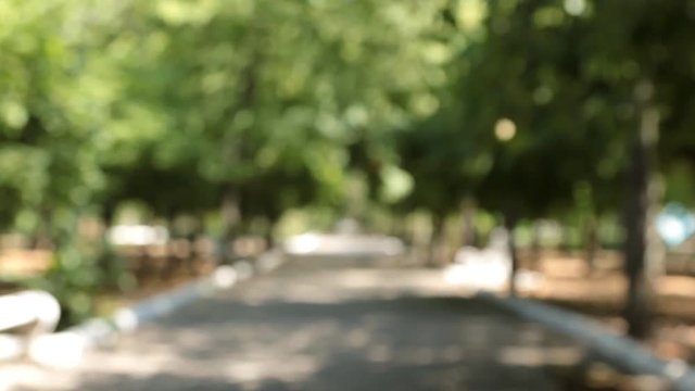 Approaching blurred alley and white benches with the focus at the end of the video .