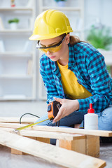 Female repairman carpenter cutting joining wooden planks doing r