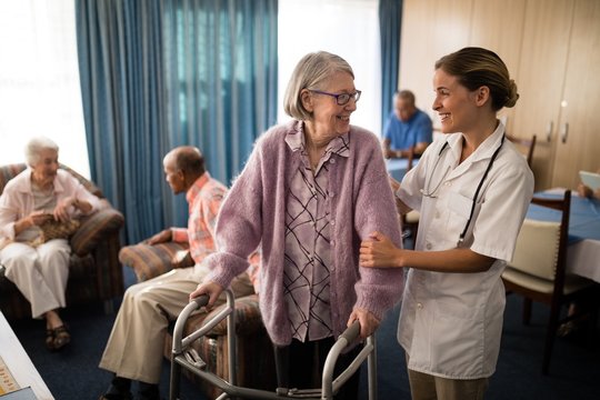 Smiling female doctor looking at senior woman standing with