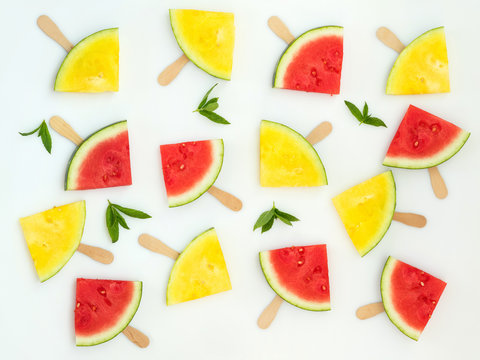 Red and yellow watermelon slices on sticks