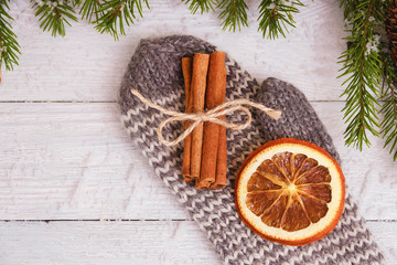 dried orange and cinnamon sticks on glove. wooden background. Christmas concept