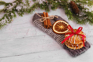 Biscoits, orange, cinnamon sticks on glove. wooden background. Christmas concept