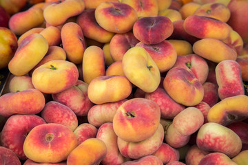Saturn peach background. Pan tao peach, Prunus persica, flat peach, donut/ doughnut peach fruits on the market.