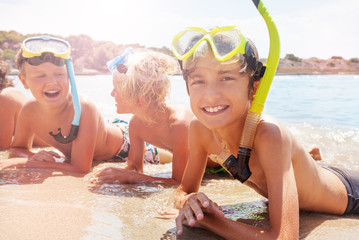 Group of laughing kids in scuba mask on the beach