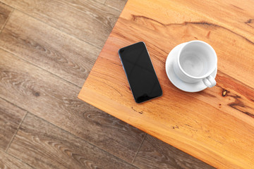 Mobile phone with blank screen mockup on wood table background