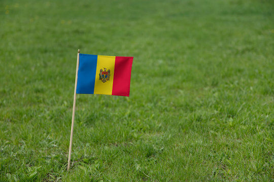Moldova flag, Moldovan flag on a green grass lawn field background. National flag of Moldova waving outdoor