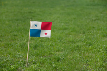 Obraz premium Panama flag. Panamanian flag on a green grass field, lawn background. National flag of Panama waving outdoors