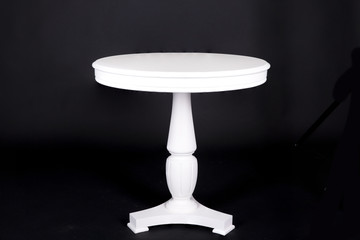  White round table on a black background