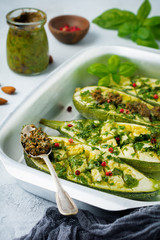 Grilled spicy zucchini with pepper and pesto sauce in aluminum form on a gray concrete background. Selective background. Top view. Copy space.