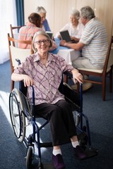 Fototapeta na wymiar Portrait of smiling disabled senior woman sitting on wheelchair