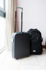 A Luggage and a backpack are packed in hotel room