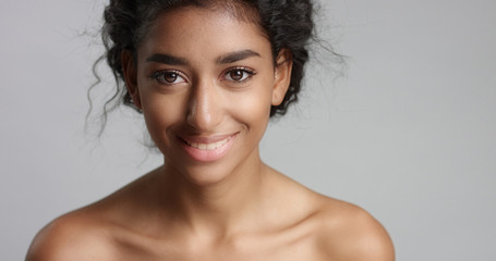 happy serene young woman with beautiful olive skin and curly hair ideal skin and brown eyes