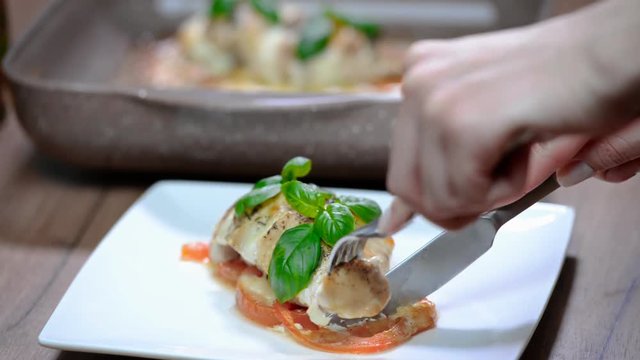 Woman eat delicious chicken fillet baked with caprese