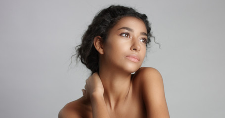 happy serene young woman with beautiful olive skin and curly hair ideal skin and brown eyes