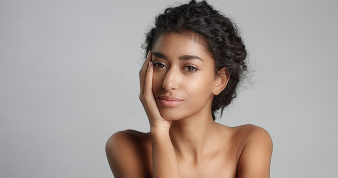 happy serene young woman with beautiful olive skin and curly hair ideal skin and brown eyes