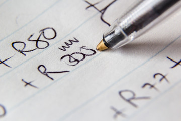 A close up macro image of a pen on paper. This image can be used to represent accounting.