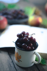 A bunch of grapes in a white mug.
