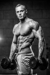Fototapeta na wymiar Attractive model young man training in gym