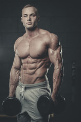 Obraz na płótnie Canvas Handsome model young man training abs in gym