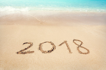 2018 written on sandy beach