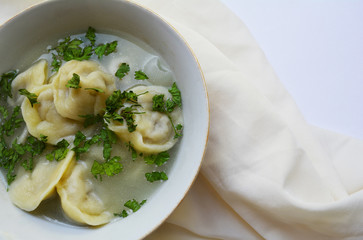 dumplings, a plate of dumplings in broth and herbs on the table
