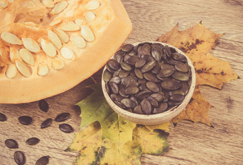 Pumpkin seeds on a wooden background.