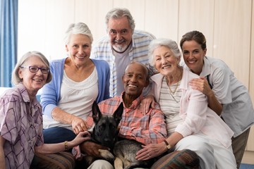 Portrait of smiling doctor and senior friends with dog