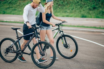 Fototapeta na wymiar young couple walking bikes together on the road