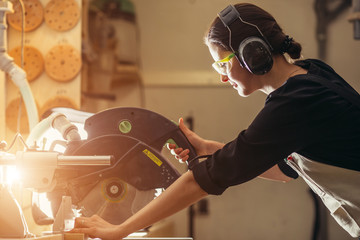 carpenters cutting wooden plank with a circular saw