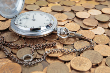 Pocket watch on the coins background