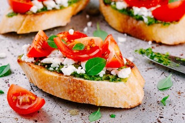 bruschetta with pesto  sauce, feta cheese, tomatoes and basil