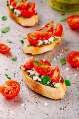 bruschetta with pesto  sauce, feta cheese, tomatoes and basil