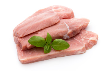 Fresh pork fillet with basil on a white background.