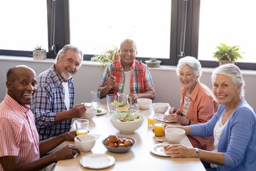 Portrait of senior people having breakfast at table