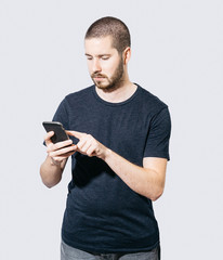 Man using smartphone against plain background
