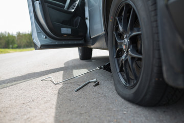 Replacing wheels on a car, jack holds the body in raised position