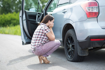 businesswoman in the city with flat tire frustrated