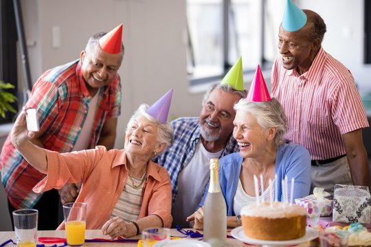 Smiling senior people taking selfie at party